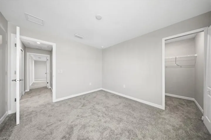 Spare room featuring carpet flooring and baseboards