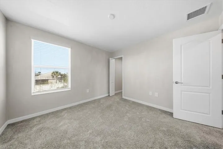 Carpeted spare room with baseboards