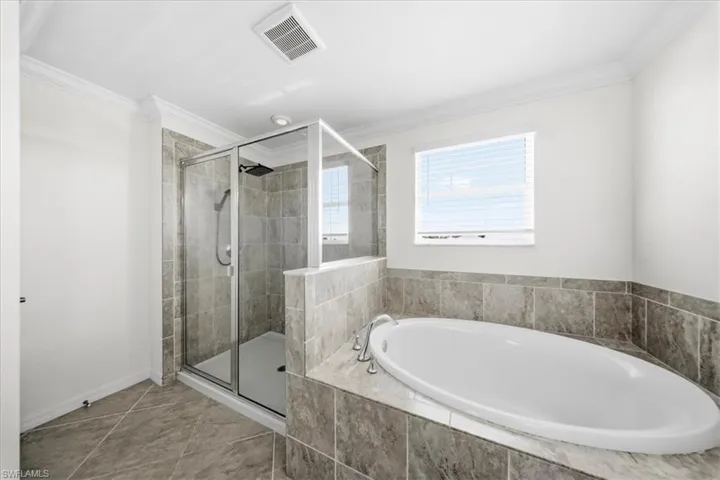 Full bath featuring a bath, vanity, and ornamental molding