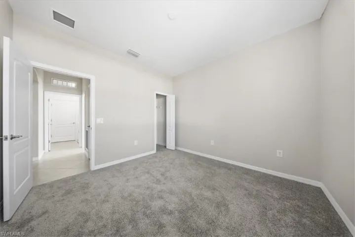 Spare room with light carpet and baseboards
