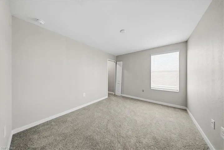 Unfurnished bedroom featuring light colored carpet and baseboards