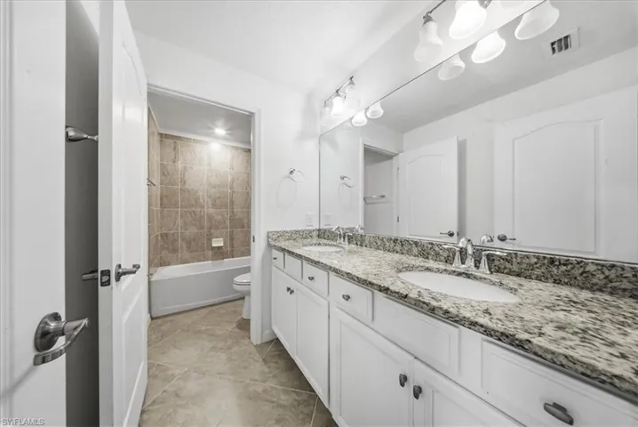 Empty room with light colored carpet and baseboards