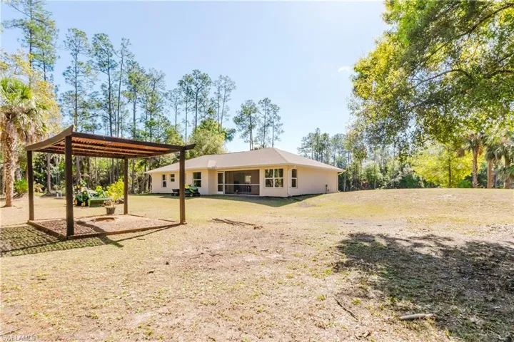 Rear view of house with a yard, pergola area perfect for fire pit.