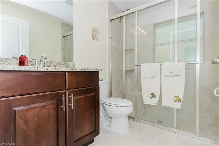Bathroom with vanity, a shower stall, and light tile patterned floors
