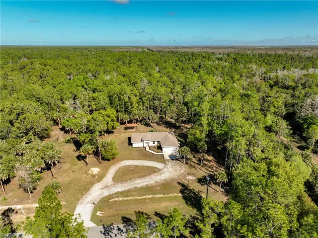 Aerial view of property's location with both cleared land and greenery.