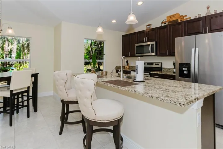 Kitchen with counter seating, casual dining area, granite counter top.