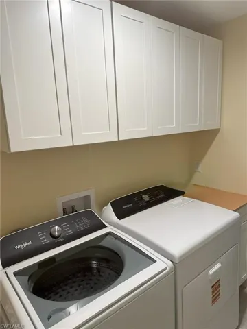 Laundry room located off garage, with cabinet storage space.