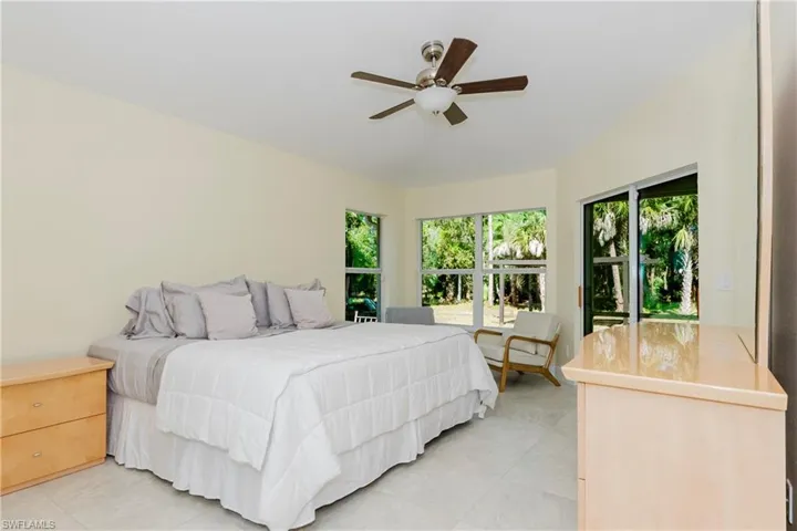 Master Bedroom with multiple windows, ceiling fan, sitting area.