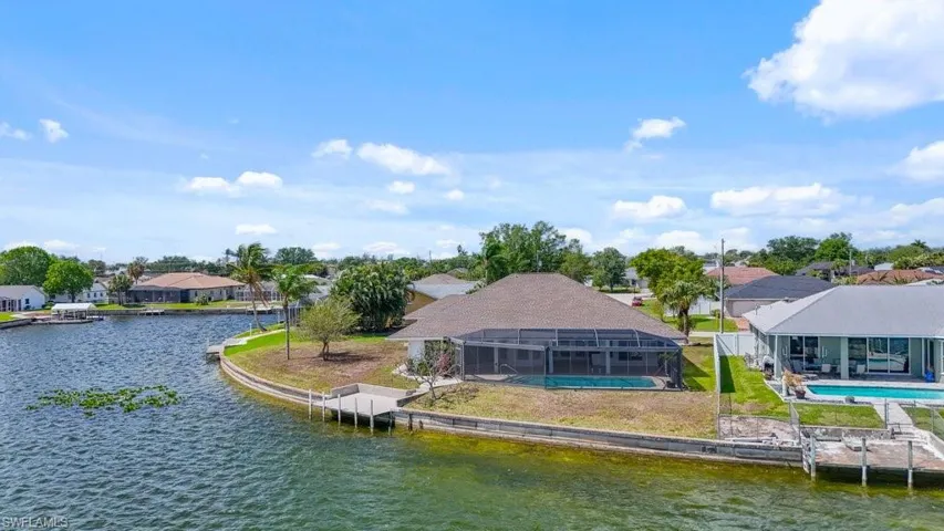 Dock featuring a sunroom, a water view, a residential view, and an outdoor pool