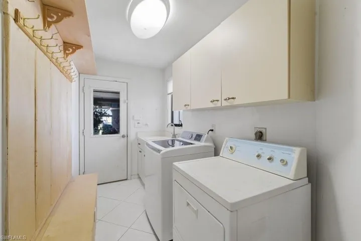 Laundry room featuring cabinet space, independent washer and dryer, and light tile patterned floors