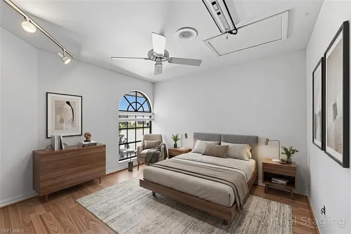 Bedroom with light wood-style flooring, rail lighting, and ceiling fan