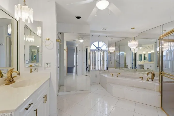 Full bathroom featuring vanity, suspended lighting, light tile patterned floors, a garden tub, and ceiling fan