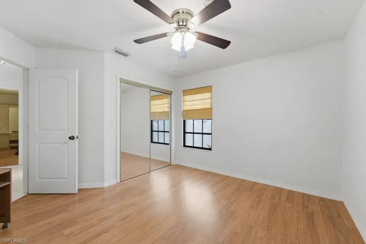 Unfurnished bedroom featuring light wood finished floors, a closet, and ceiling fan