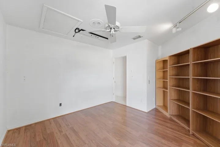Spare room with a ceiling fan, light wood finished floors, and rail lighting
