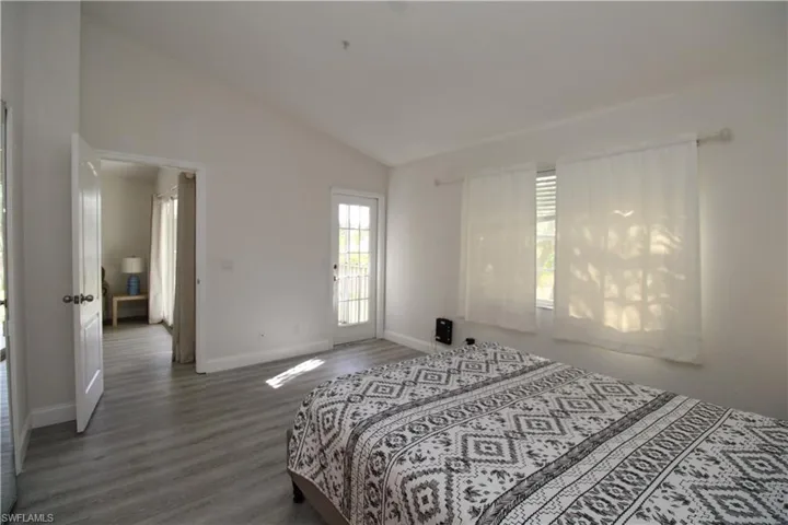 Bedroom featuring dark hardwood / wood-style floors and high vaulted ceiling