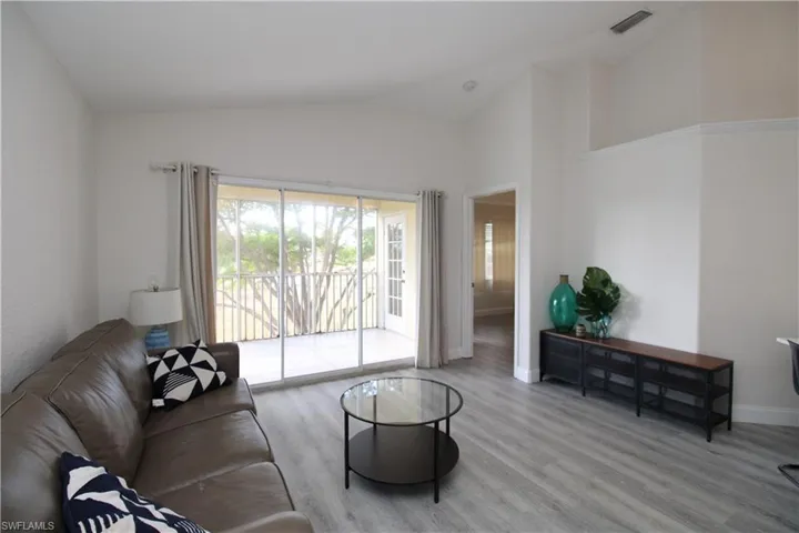 Living room featuring light wood-type flooring and high vaulted ceiling