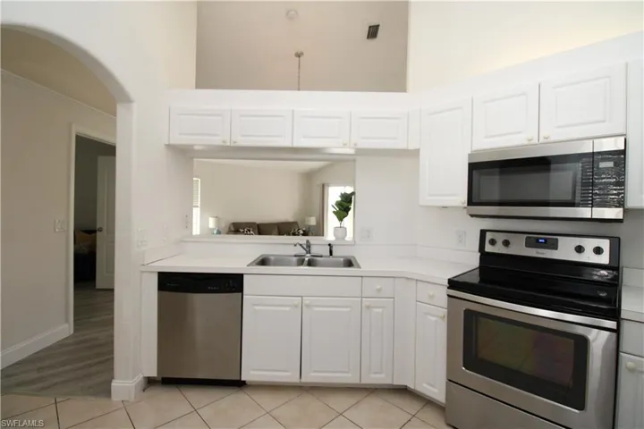 Kitchen with white cabinets, sink, light hardwood / wood-style flooring, and appliances with stainless steel finishes