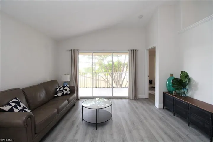 Living room with light hardwood / wood-style flooring and lofted ceiling