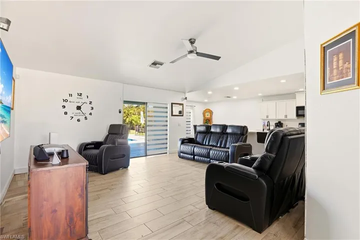 Living room featuring wood tiled floors, lofted ceiling, and a ceiling fan
