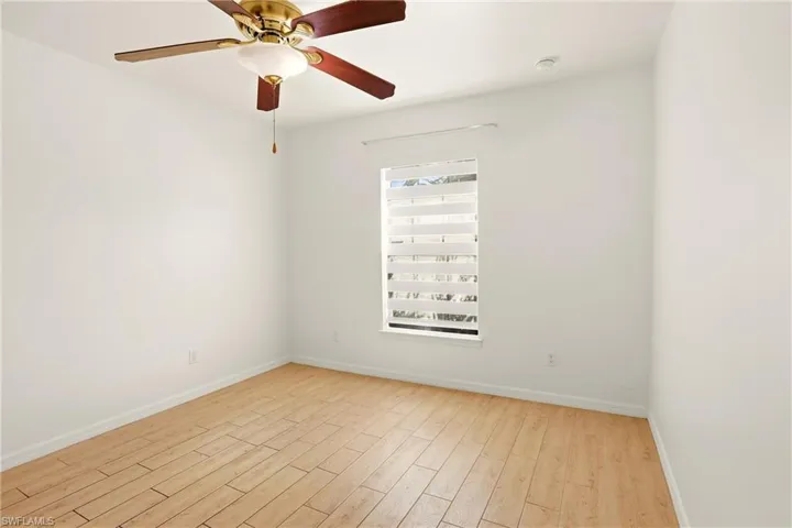 Empty room featuring light wood finished floors and ceiling fan