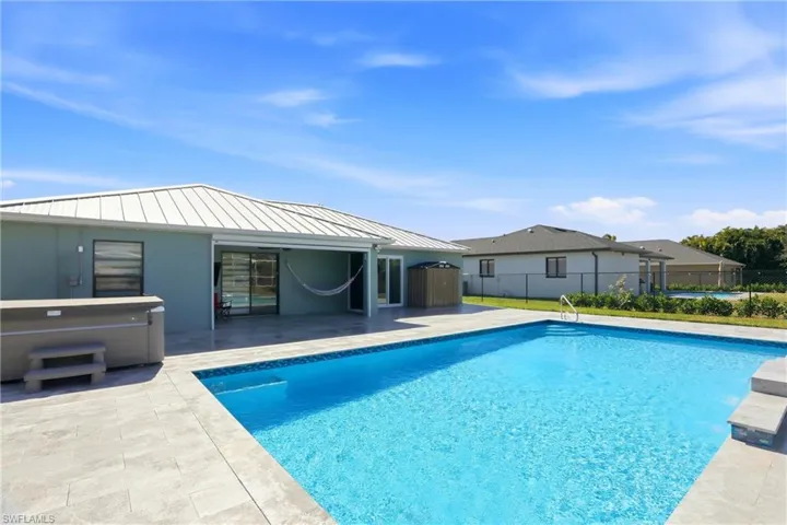 View of pool with patio surround and a hot tub