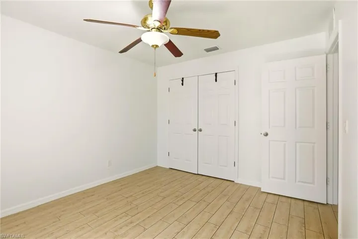 Unfurnished bedroom featuring wood tiled floors, a closet, and ceiling fan