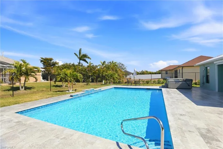 View of swimming pool featuring a fenced backyard, patio surround, and a hot tub