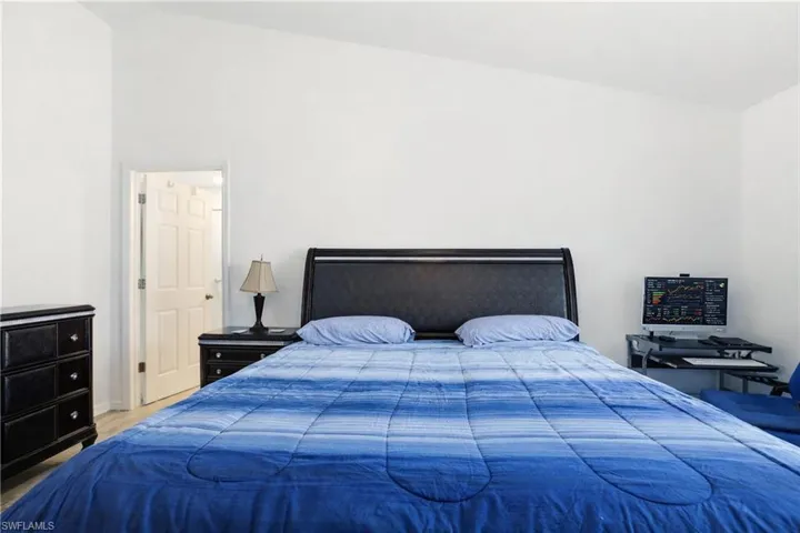 Bedroom with lofted ceiling and wood finished floors