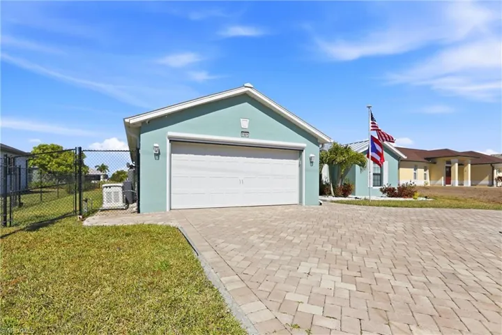 Ranch-style house with stucco siding, decorative driveway, and a garage