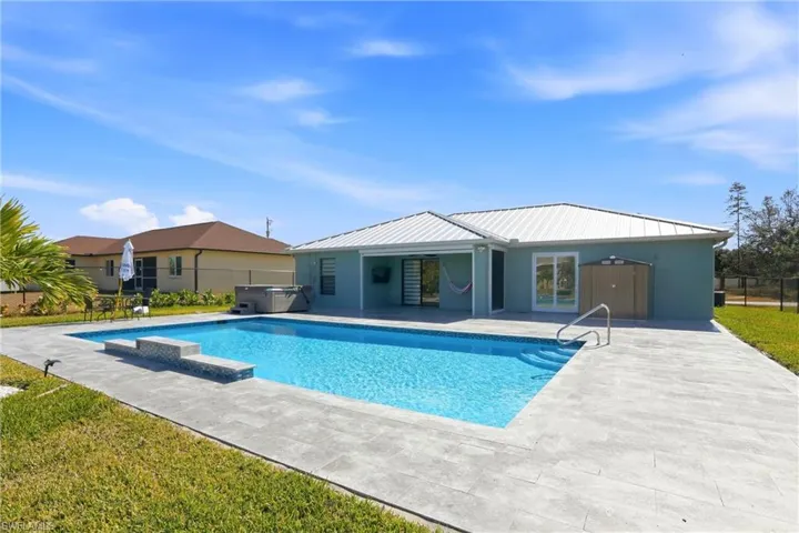 View of swimming pool with a hot tub and patio surround