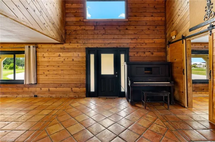 Wood-paneled interior walls with a high ceiling