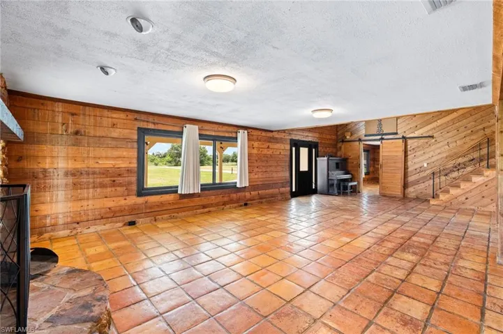 Spacious interior with terracotta tile flooring and wood-paneled walls