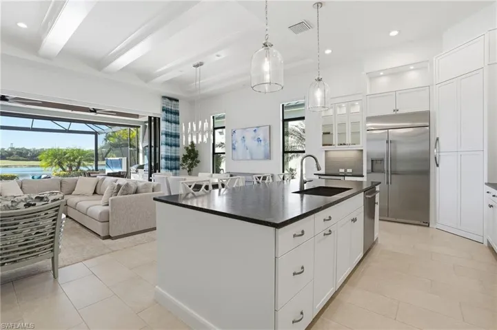 Kitchen featuring white cabinets, recessed lighting, an island with sink, stainless steel appliances, and pendant lighting