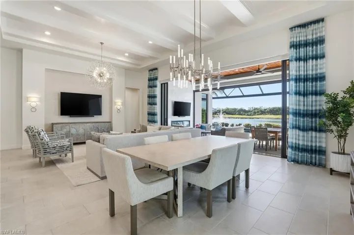 Dining area featuring a chandelier, a sunroom, beam ceiling, and recessed lighting
