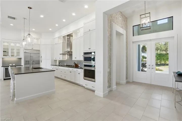 Kitchen with pendant lighting, glass insert cabinets, and a chandelier