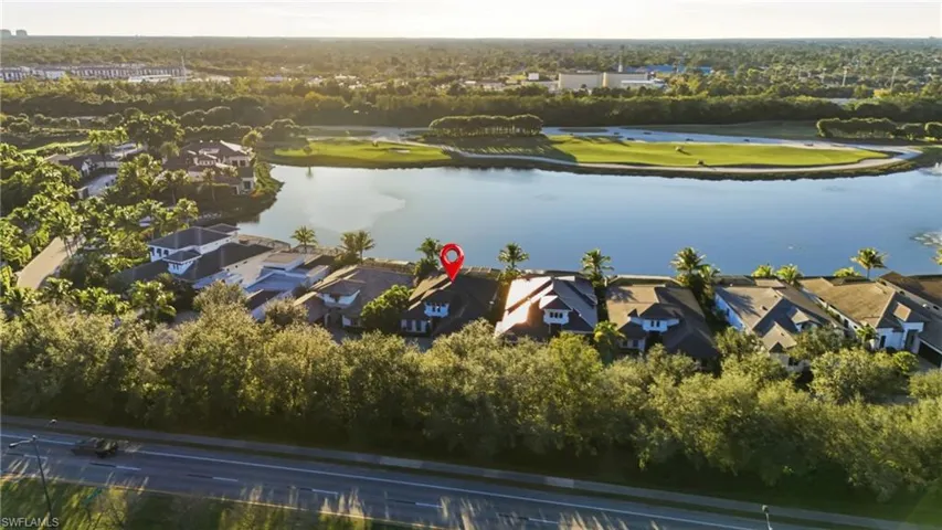 Aerial perspective of suburban area with a tree filled landscape and a large body of water