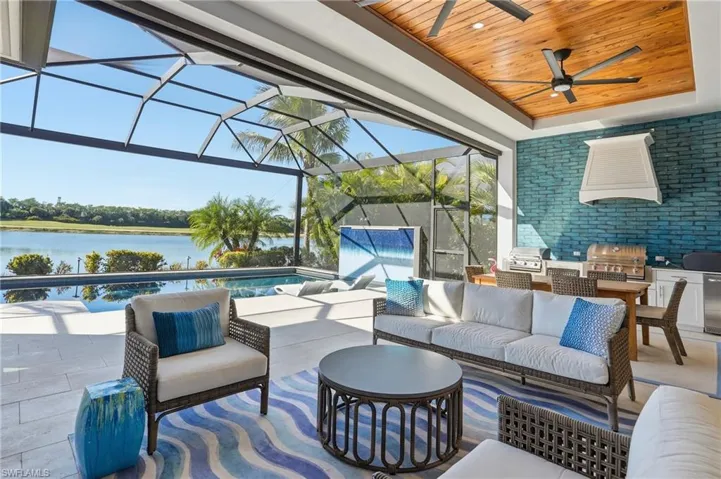 View of patio / terrace featuring an outdoor kitchen, a sunroom, an outdoor hangout area, an outdoor pool, and glass enclosure