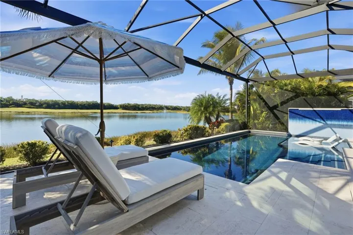 Swimming pool with a lanai, a sunroom, and a water view