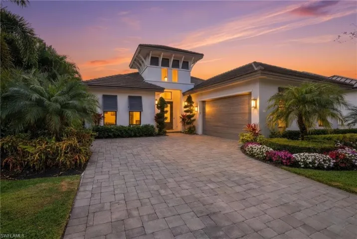 View of front of property featuring decorative driveway, stucco siding, a garage, and a tile roof