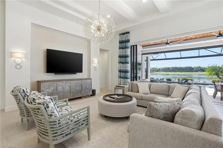 Living room with beamed ceiling, a chandelier, tile patterned floors, a sunroom, and recessed lighting