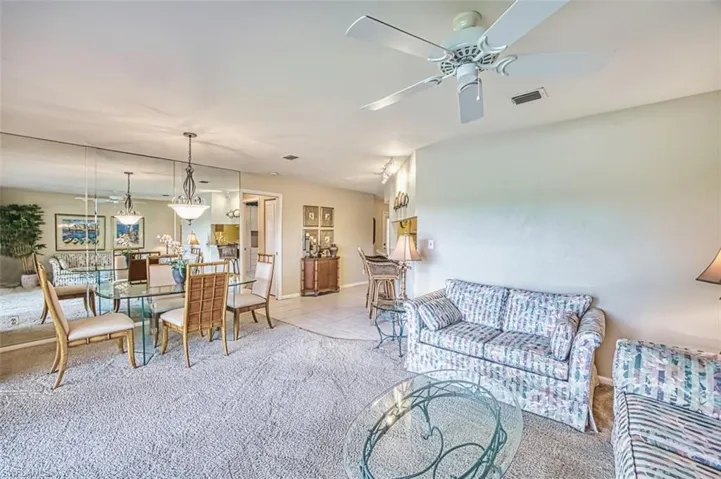 Carpeted living room featuring tile patterned flooring and a ceiling fan