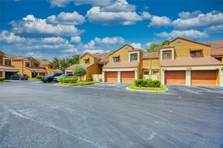 Mediterranean / spanish house with stucco siding, a tile roof, a residential view, and driveway
