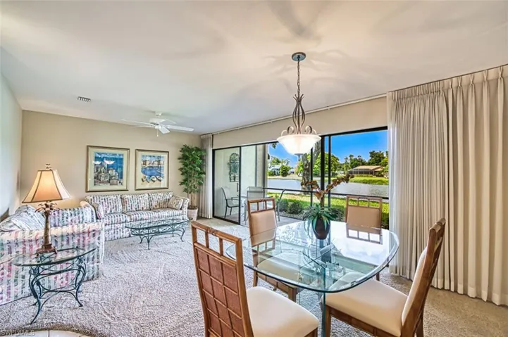 Carpeted dining room with a water view and a ceiling fan