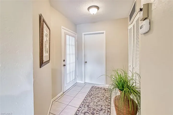 Entryway featuring tile patterned flooring and a textured wall