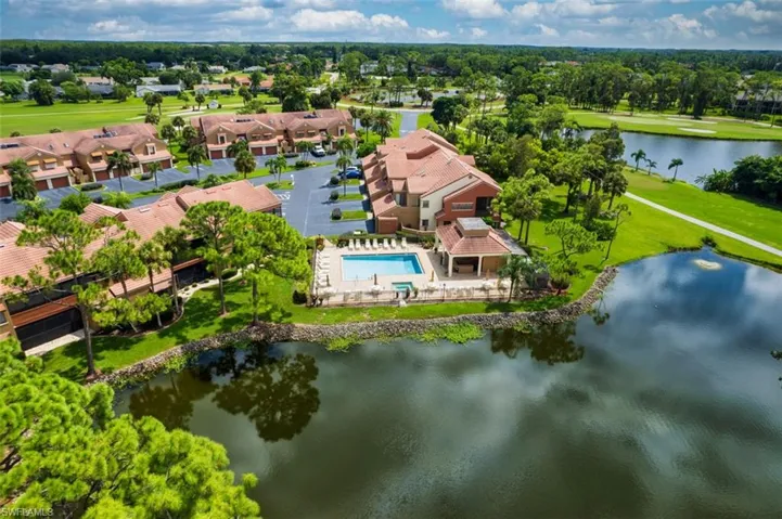 Aerial view of residential area with a large body of water and a pool area