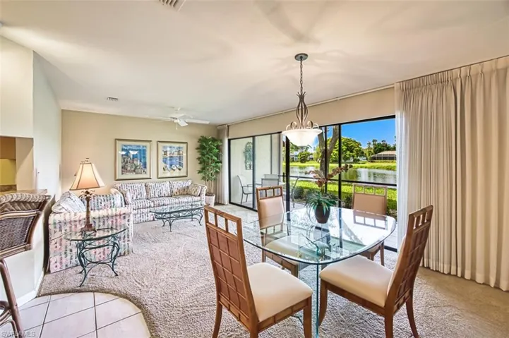 Tiled dining area featuring carpet, a water view, and ceiling fan