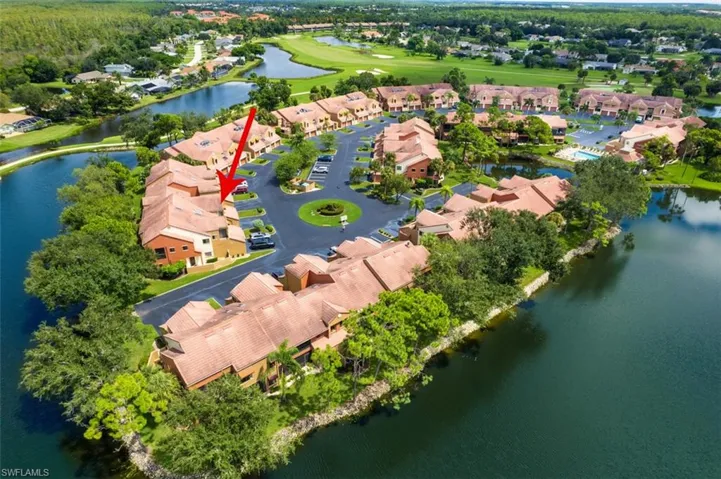 Aerial view of residential area featuring a nearby body of water and a golf club