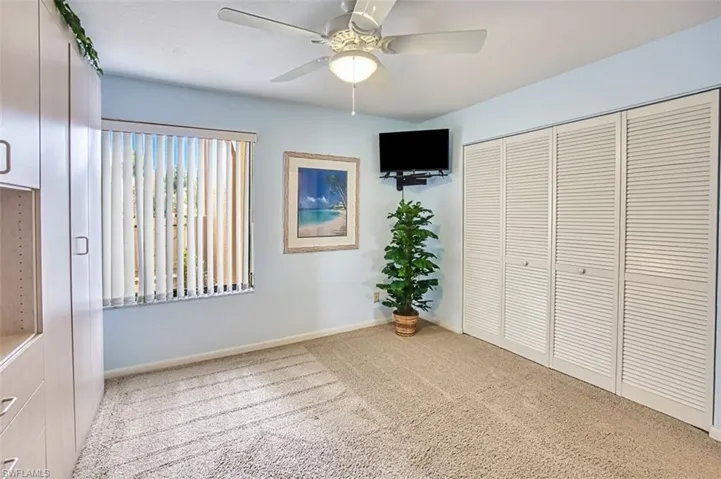 Unfurnished bedroom featuring light carpet, a ceiling fan, and a closet