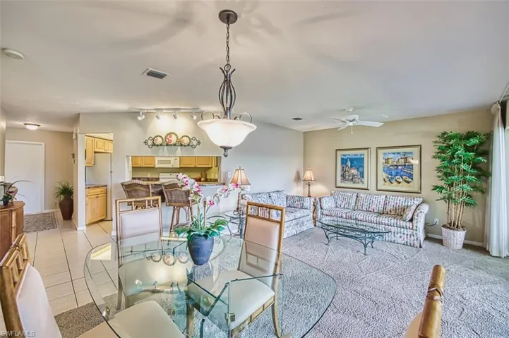 Dining area featuring light tile patterned floors, track lighting, and a ceiling fan