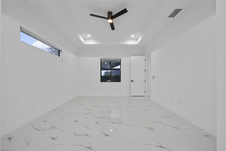 Unfurnished room with marble finish floor, recessed lighting, a raised ceiling, visible vents, and baseboards